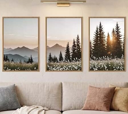 Ljust vardagsrum med naturmotiv och solbelysta granar i tre tavlor
